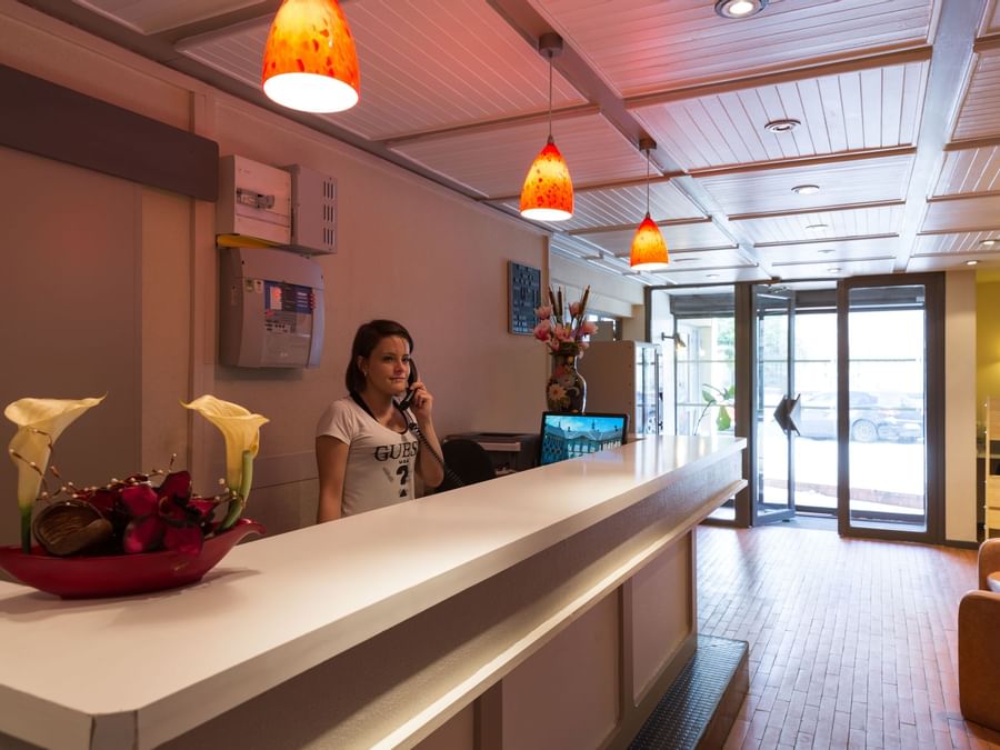 A receptionist at the reception desk in Hotel Arum