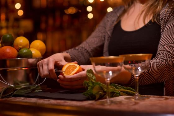 A woman peeling an orange in a restaurant at The Inn Saratoga