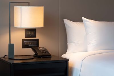 King bed with bedside lamp in Carlton Club Room at Carlton Hotel Bangkok Sukhumvit