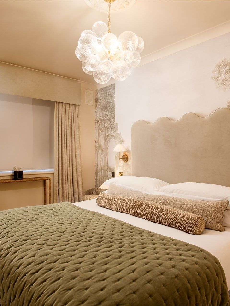 Bed between the side tables under wall lamps in Two Bedroom Apartment at The Capital Hotel, Apartments and Townhouse