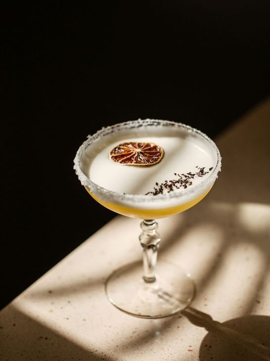 Cocktail élégant dans un verre à pied sur une table ensoleillée chez Ibiza Gran Hotel