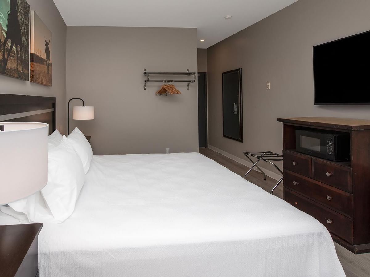 Hotel room with king-sized bed, modern furniture, and flat-screen TV.