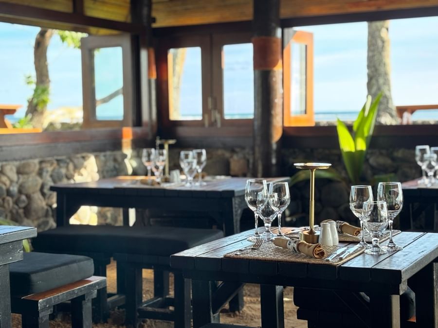 Dining setup with wine glasses and ocean view at Warwick Fiji Resort and Spa.