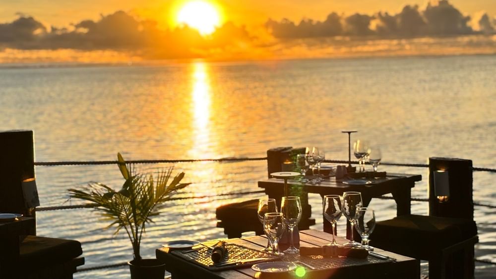 Sunset over ocean with Wicked Walu restaurant tables set for dinner at Warwick Fiji Resort and Spa, Korolevu.
