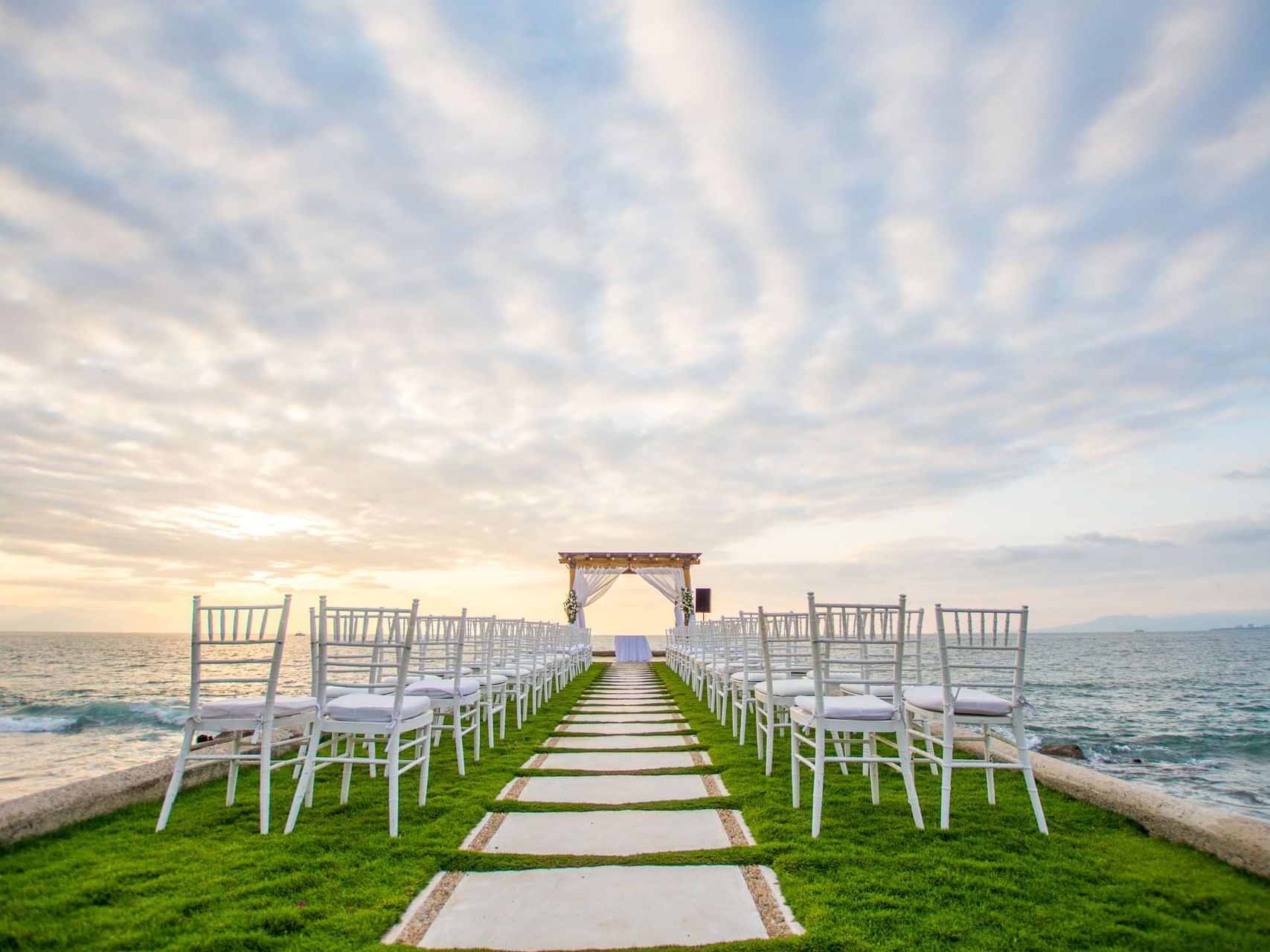 Outdoor wedding ceremony with white chairs near Buenaventura Grand Hotel and Spa