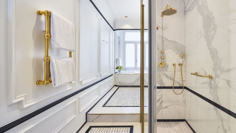 Modern bathroom featuring marble walls and a glass shower in Duke of Westminster Suite at Hôtel Westminster - Paris