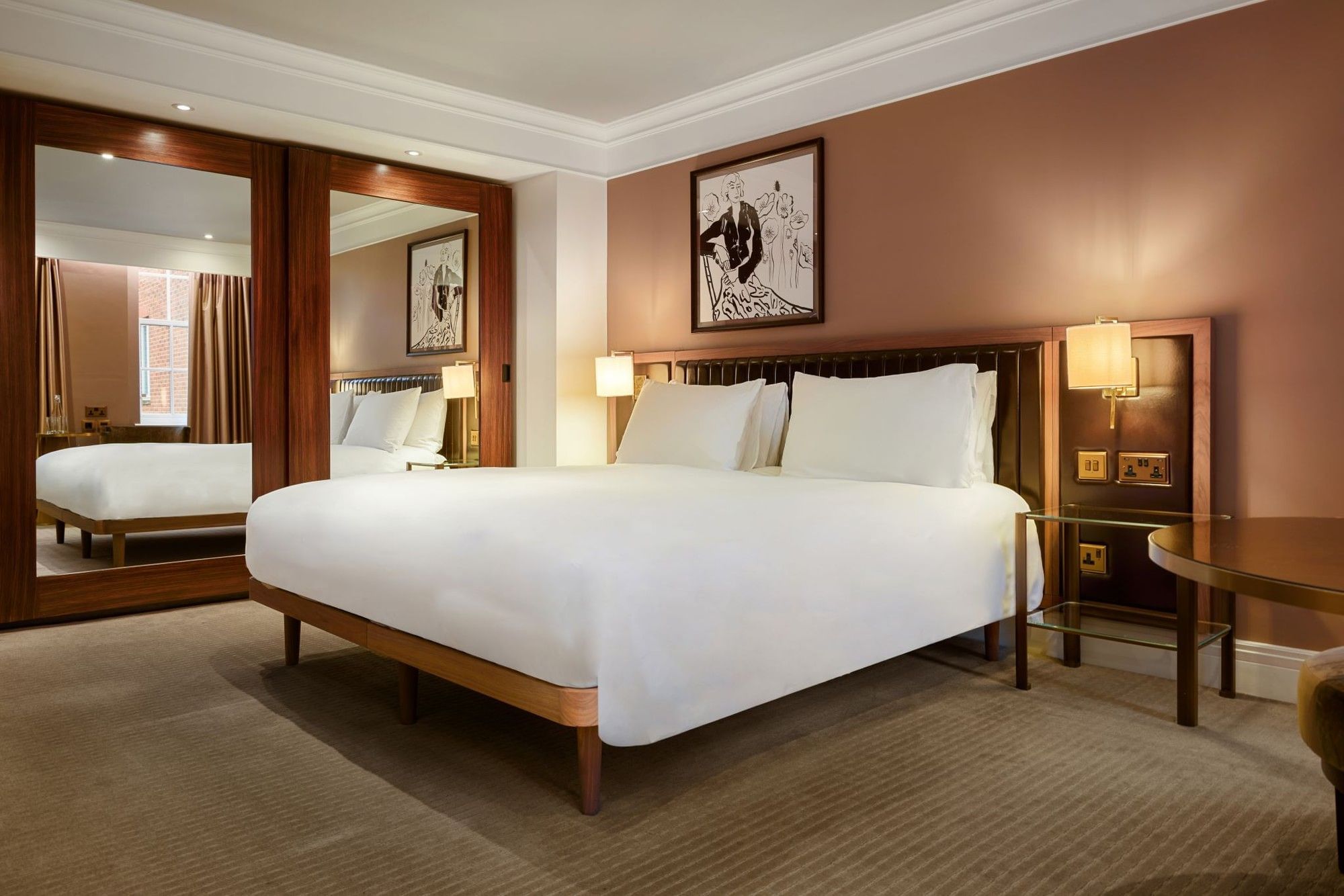 Elegant room with large bed, mirror, and artwork at The May Fair Hotel, London.