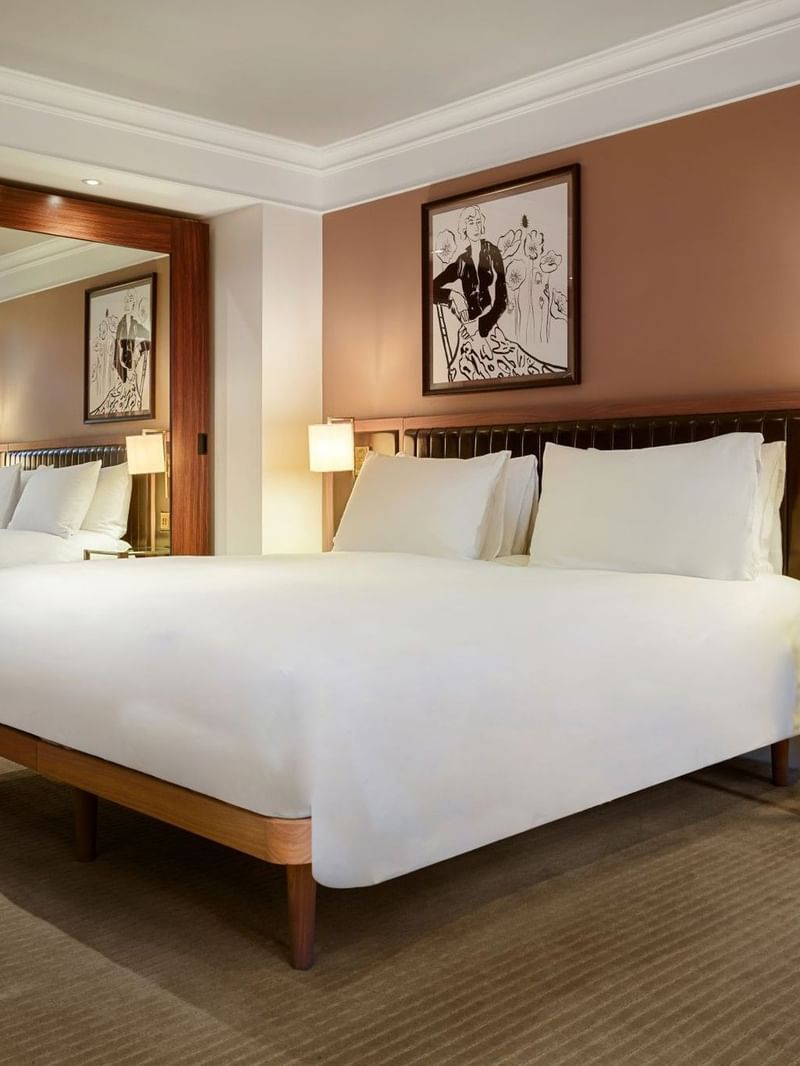 Elegant room with large bed, mirror, and artwork at The May Fair Hotel, London.