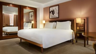 Elegant Collection Premium Room with white bedding and artwork at The May Fair Hotel, London, England.