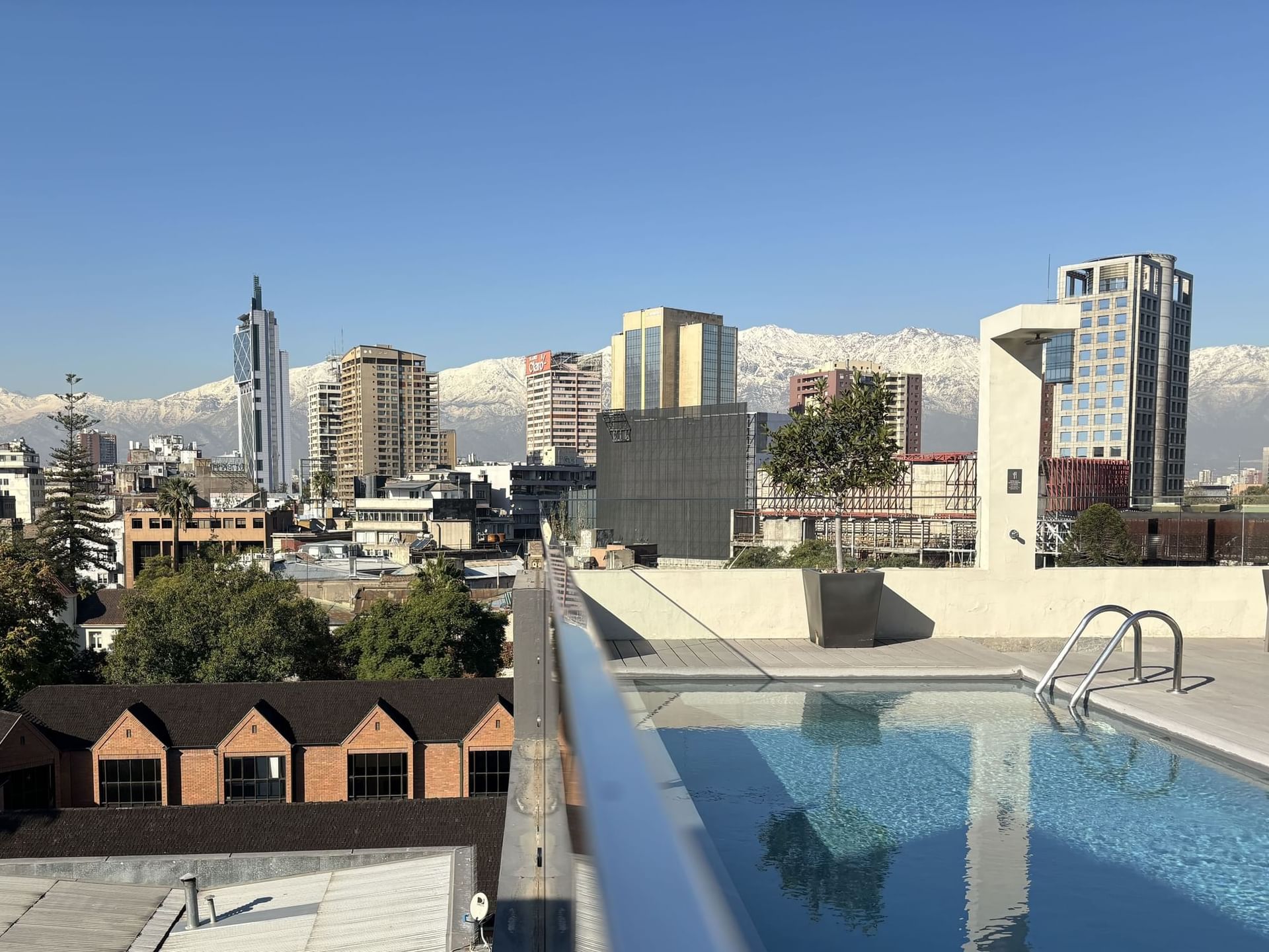 Rooftop pool with skyline and snowy mountains at Cumbres Lastarria