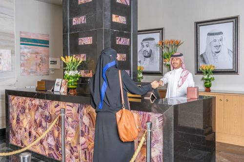 Local guest checking in by the front desk at Makeen Homes by Warwick - Riyadh