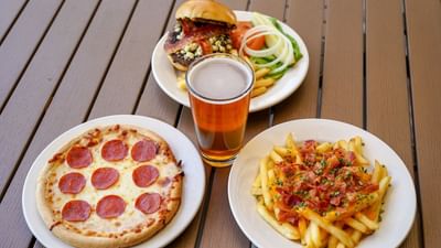 Pizza, french fries and a burger with beer served in Zebras Sports Bar by Rosen Inn at Pointe Orlando