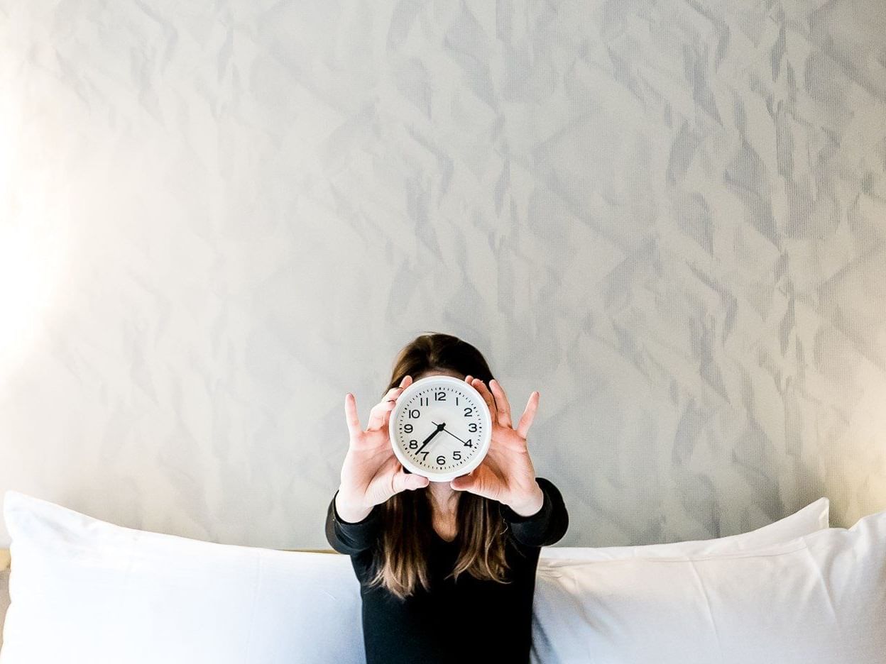 Girl holding a clock infront of her face at The Time New York