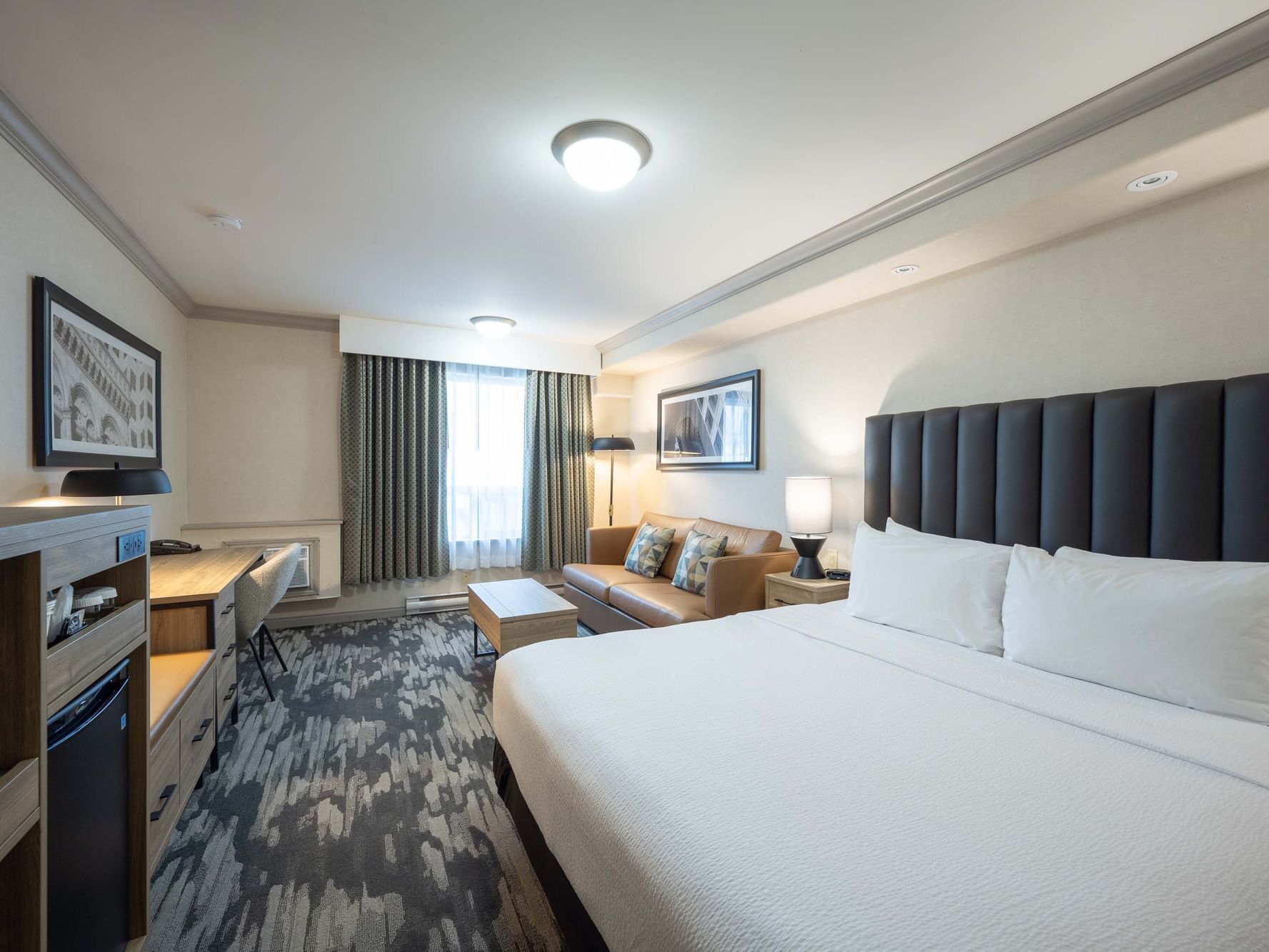 TV-facing bed and seating area in Standard Room at Sandman Hotel & Suites Winnipeg Airport