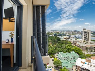 Private balcony with panoramic city and river views at UniLodge on Margaret, featuring modern glass doors and urban skyline.