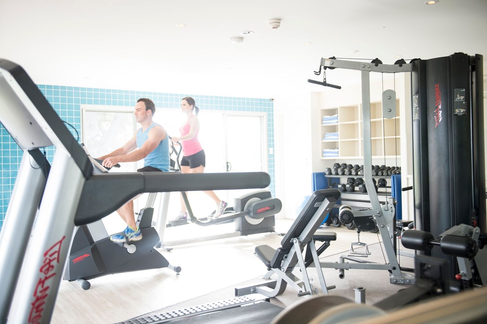 Young woman & man exercising at the gym of Novotel Barossa