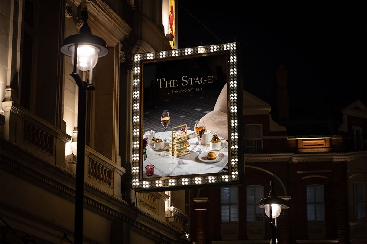 Illuminated exterior of The Stage Champagne Bar at The Londoner at night