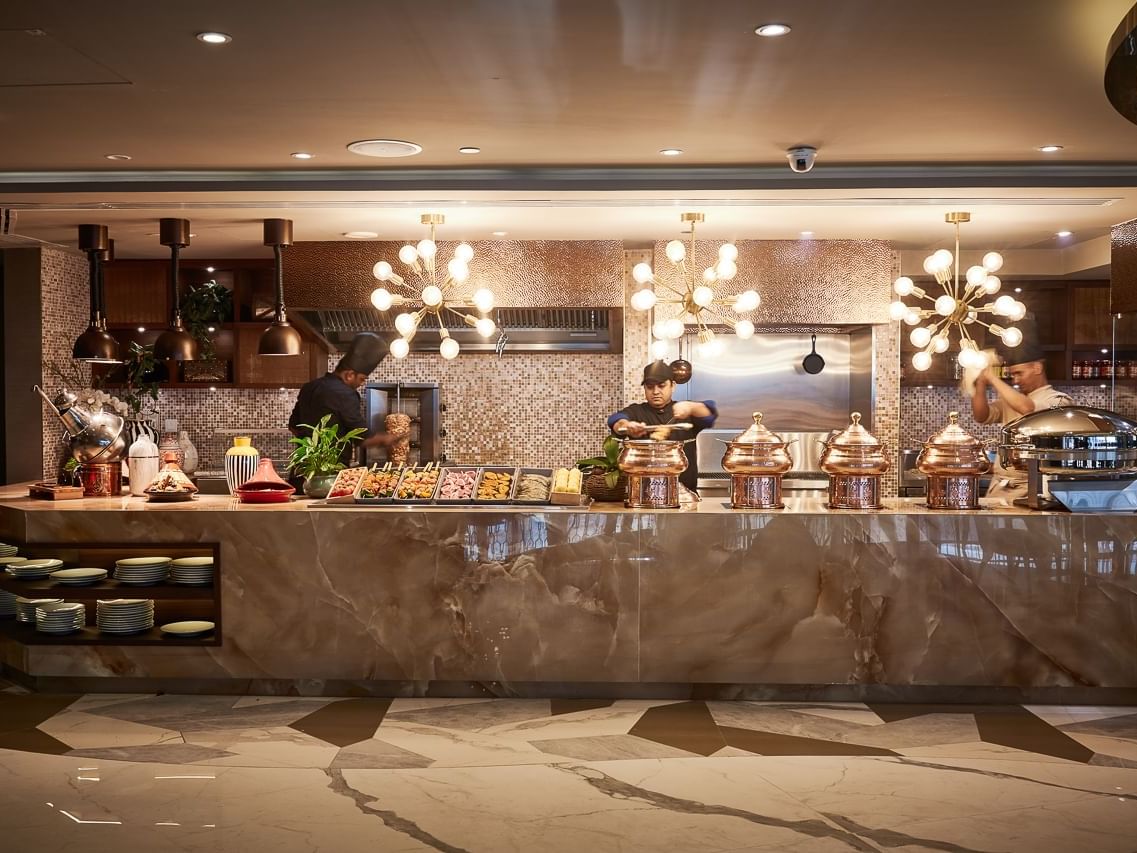 Illuminated buffet counter with culinary in The Stage Restaurant at Paramount Hotel Dubai