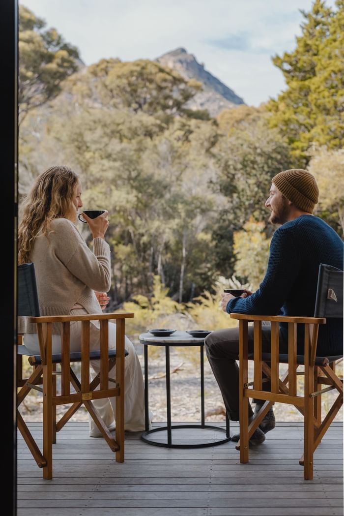 Couple enjoying wine on the terrace overlooking the view at Freycinet Lodge