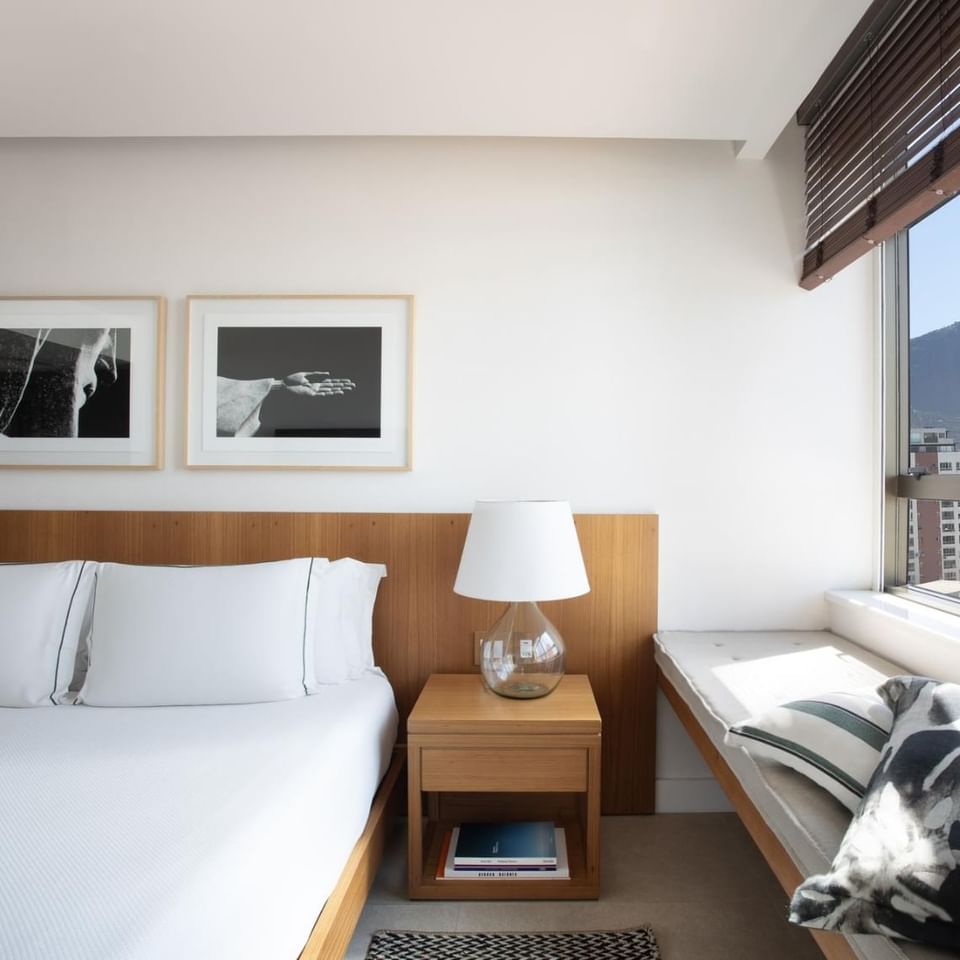 Interior view of Deluxe room with bedside lamps at Janeiro Hotel