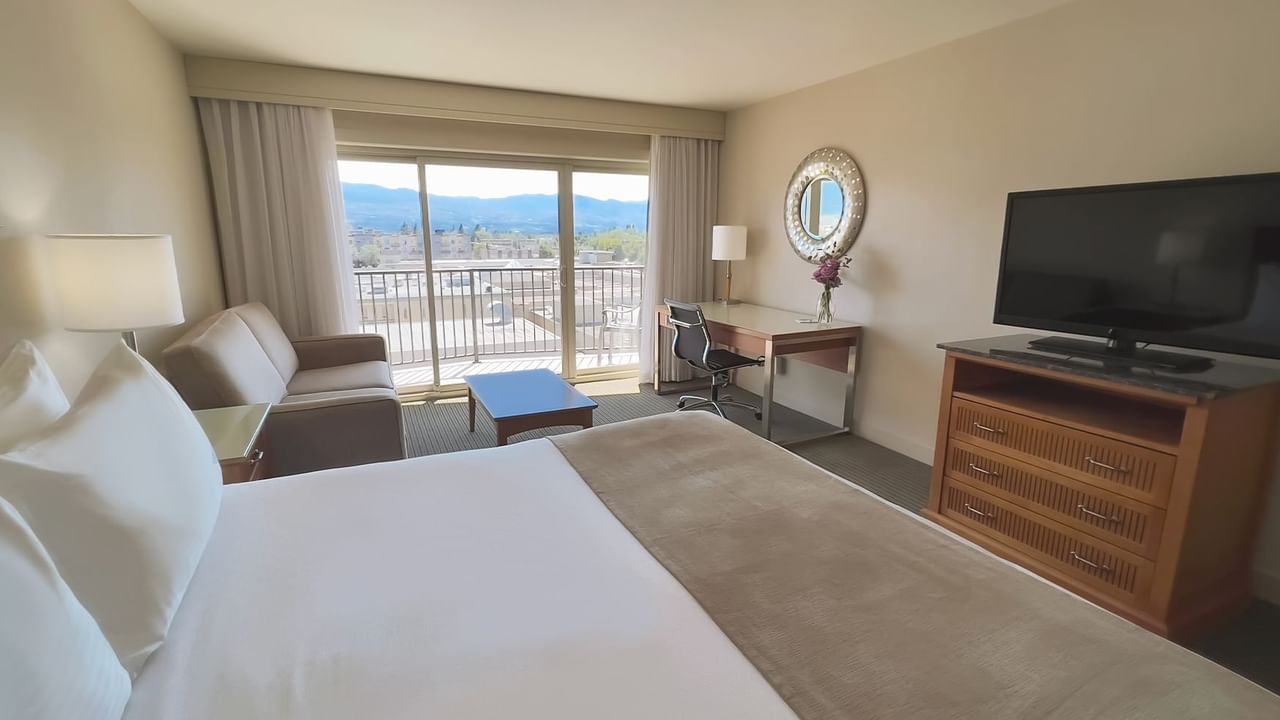 Guest room with king bed, balcony, sofa bed, table, desk, chair