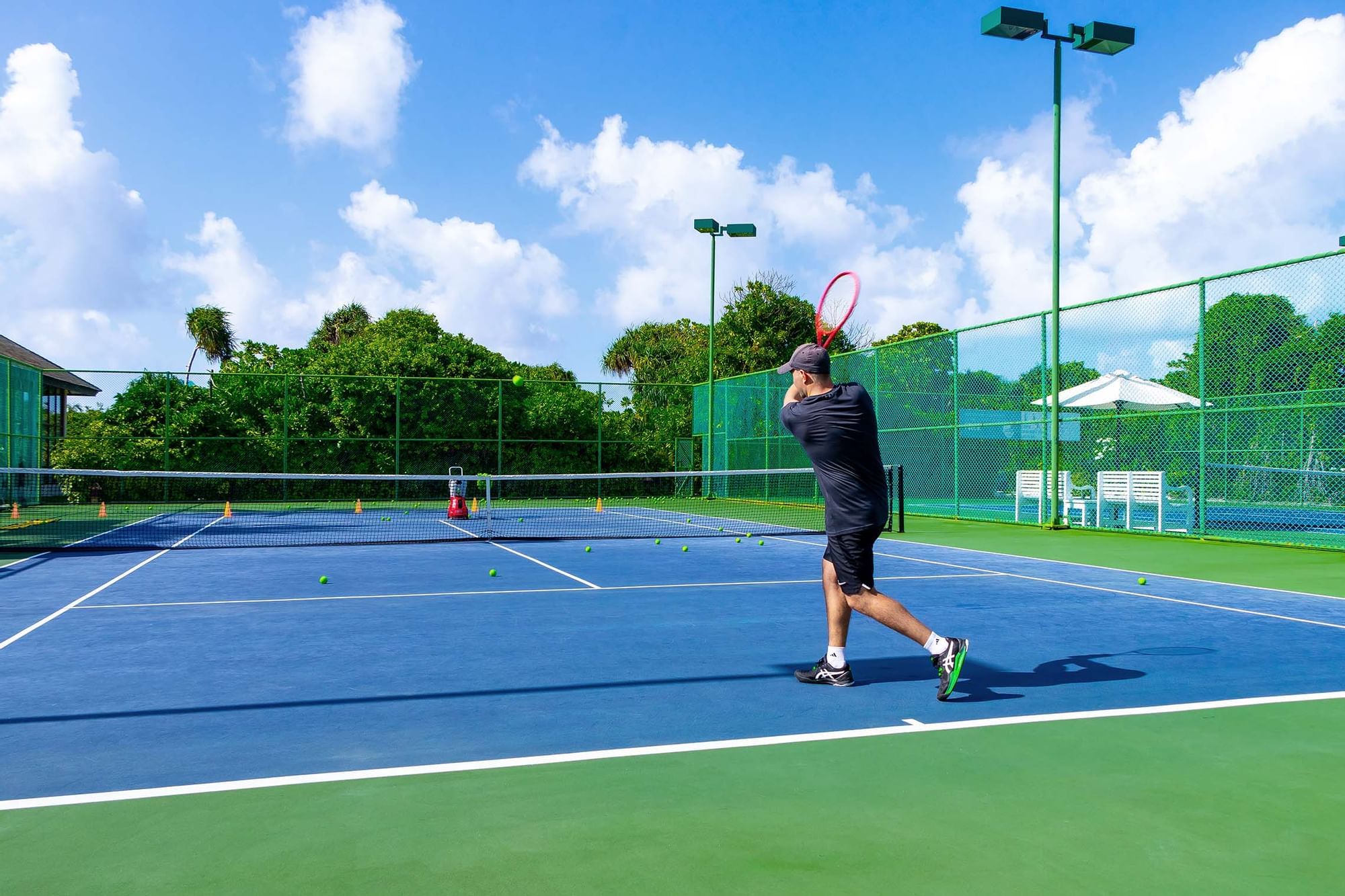 Two men playing tennis on the court at The Signature Collection