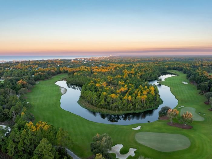 Camp Creek Golf Course with water features and lush greenery at sunset.