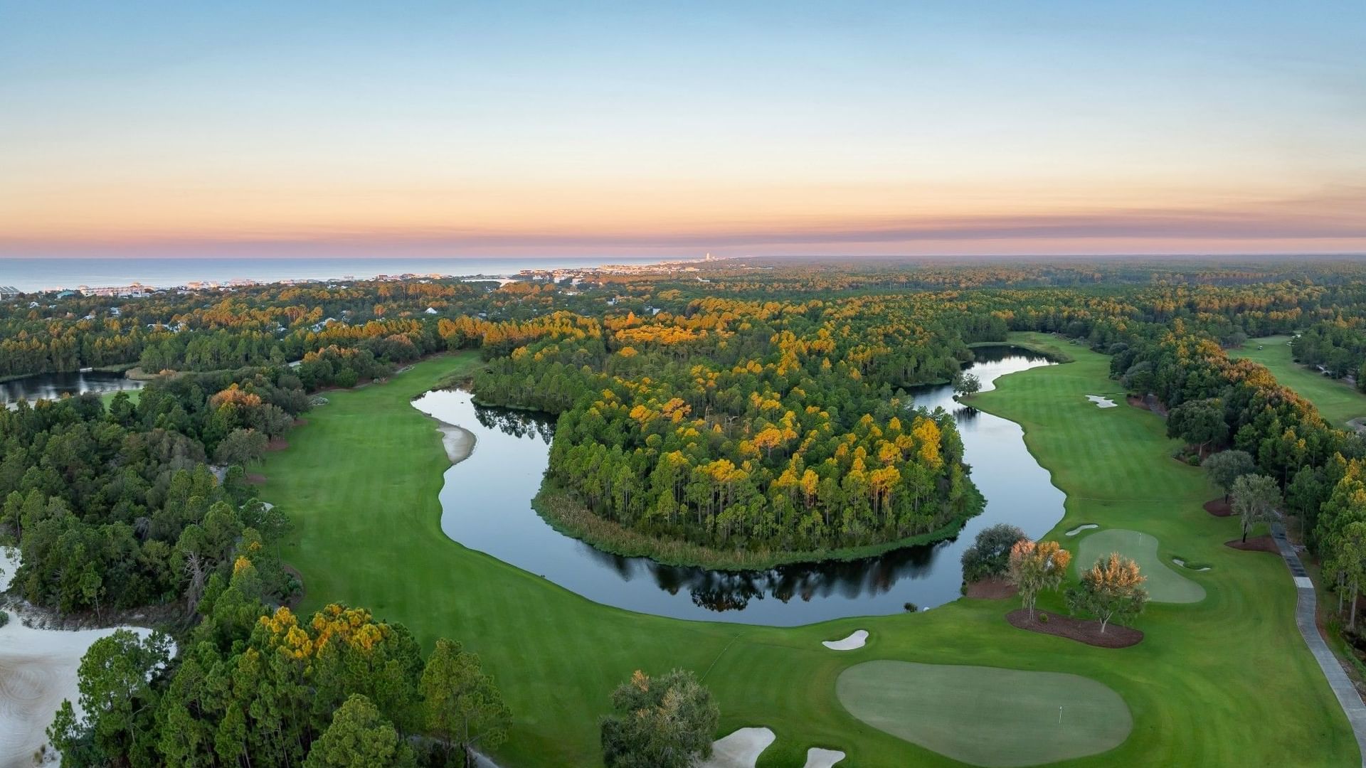 Camp Creek Golf Course with water features and lush greenery at sunset.
