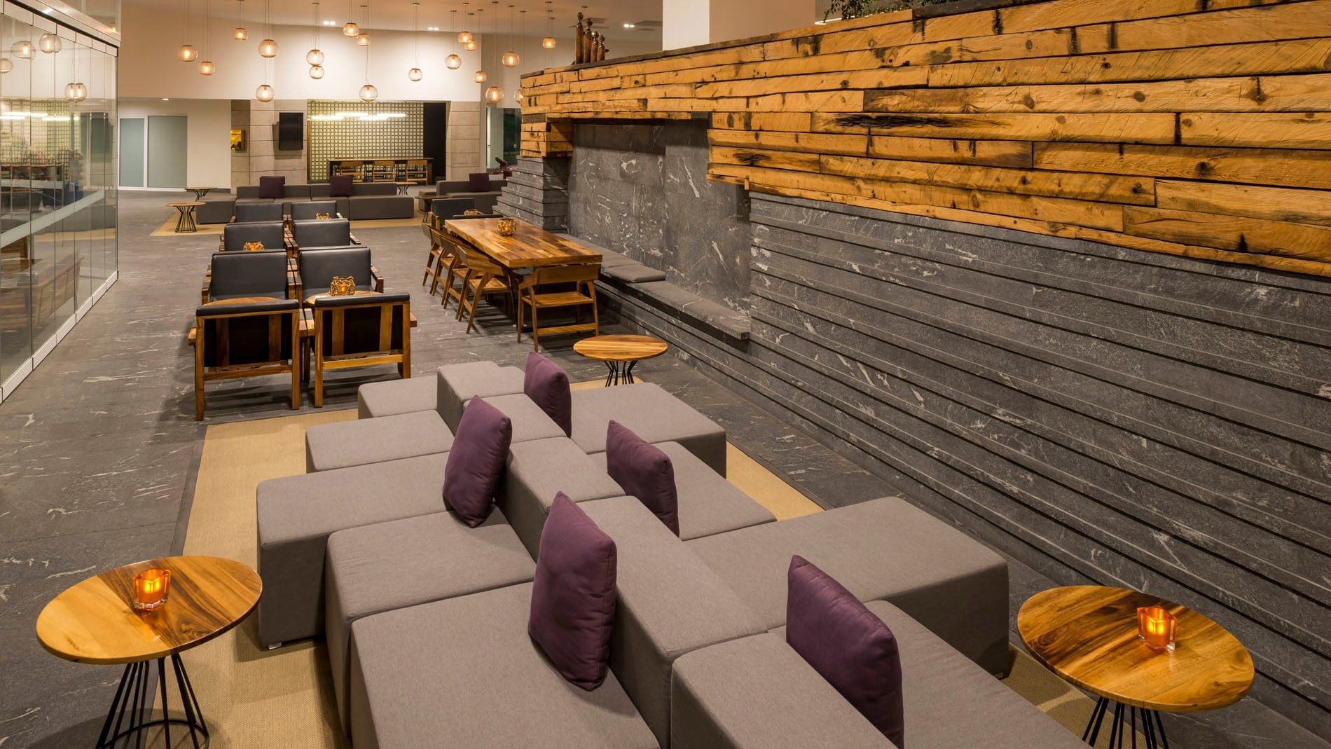 Blue Bar with purple pillows and a textured wood-accented wall at Camino Real Puebla Angelopolis