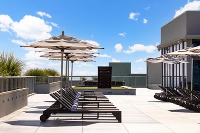 Sun beds with umbrellas on the pool deck at Costa Beach Resort