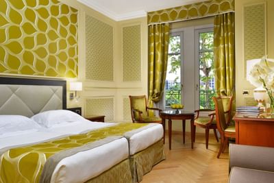 King bed, coffee table, work desk with fresh flowers & lamp in Superior twin room at Grand Visconti Palace