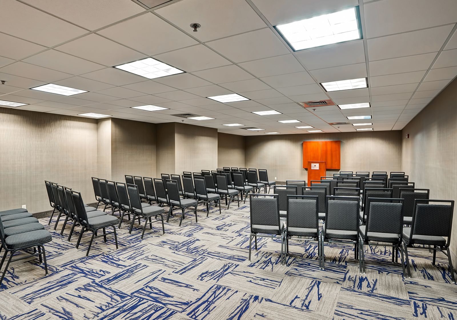 Rows of chairs facing a podium in a meeting room at Grove Hotel