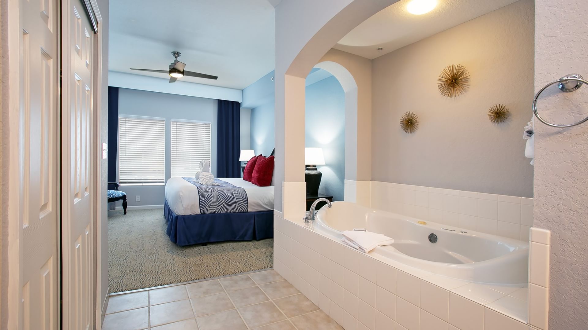 A suite with a large bed and a jacuzzi in the bathroom