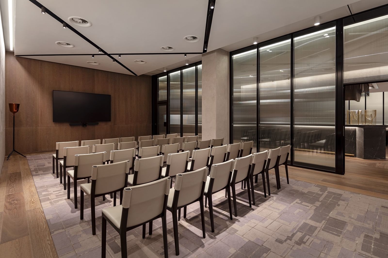 Royal Academy of Arts meeting room at The Londoner Hotel, with chairs arranged neatly facing a TV