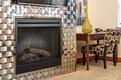 Stainless steel weaving in fireplace next to work desk in King Superior at Retro Suites Hotel