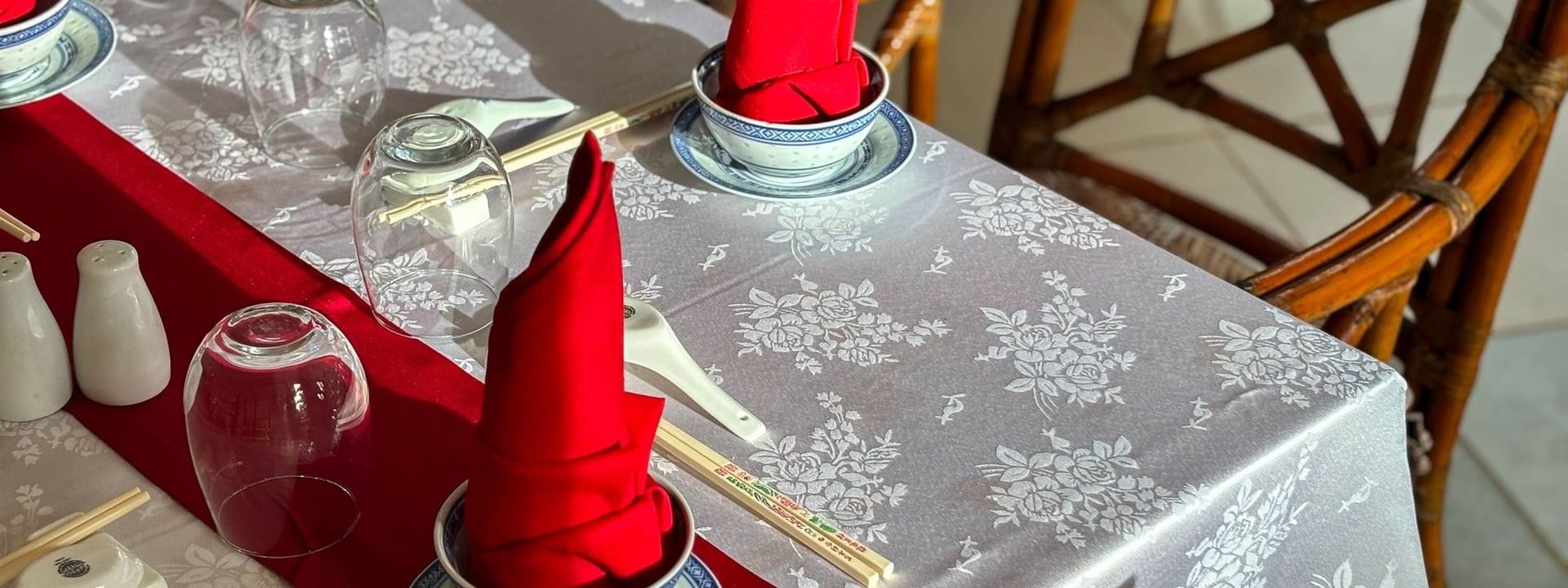 Elegantly set dining table with red napkins and bamboo chairs at Bamboo Terrace, The Naviti Resort, Korolevu