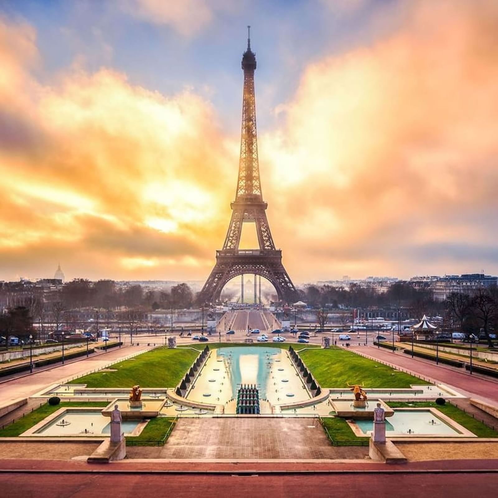 Eiffel Tower by a water garden under a golden sunset sky near Warwick Paris Champs Elysées