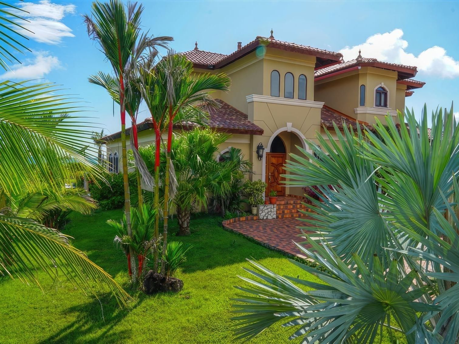 Exterior of Hacienda Del Rey with lush palm trees at Las Olas Beach Resort, one of the best hotels in David Panama