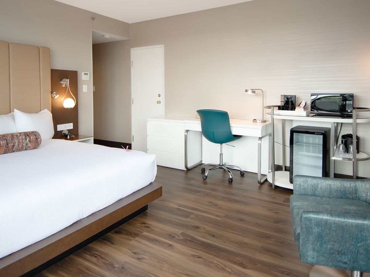 Hotel guestroom with a king size bed and work desk with chairs