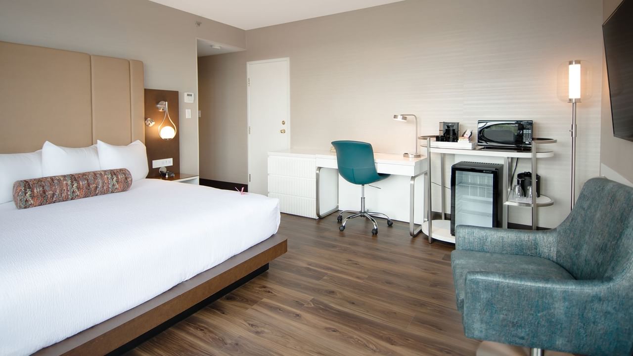 Hotel guestroom with a king size bed and work desk with chairs
