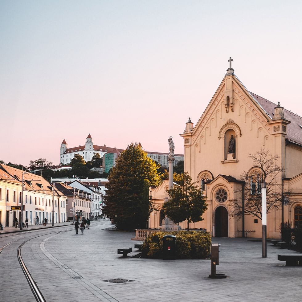 Tranquil city street at dusk with a church and castle near Falkensteiner Hotel Bratislava