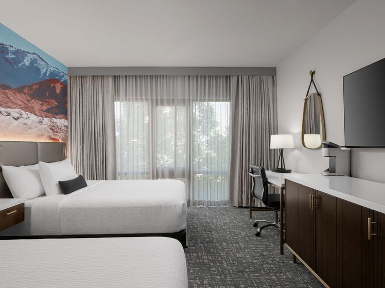 Boutique Double Queen bedroom with an accent wall mural depicting a picturesque snow-covered mountain at Hotel 43 Boise