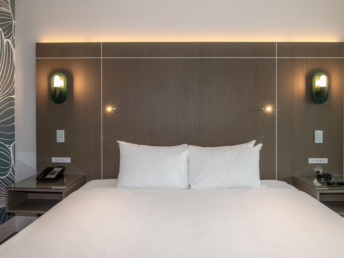 A hotel room with a king bed.