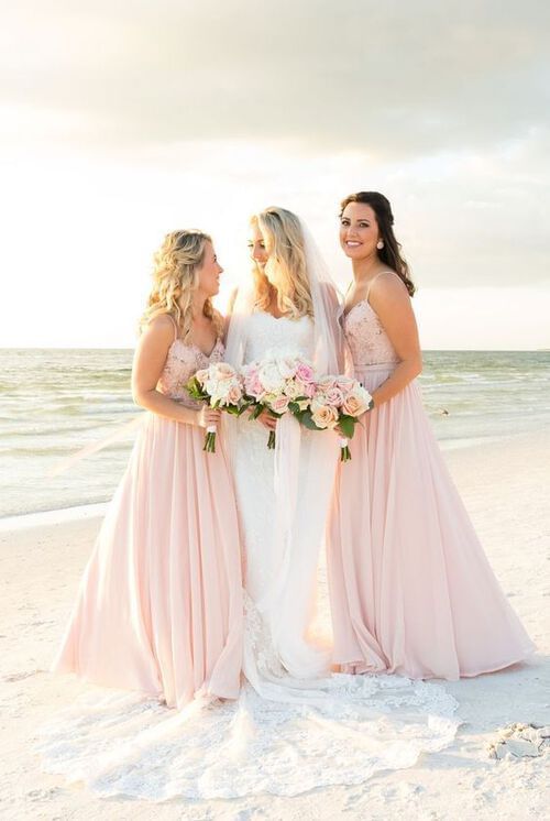 Two bridesmaids stand with a bride on the beach near Grand Park Kodhipparu, Maldives