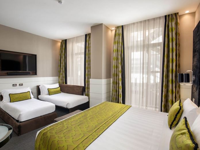 TV Facing cozy bed by the window in Family Room at The Glam Hotel