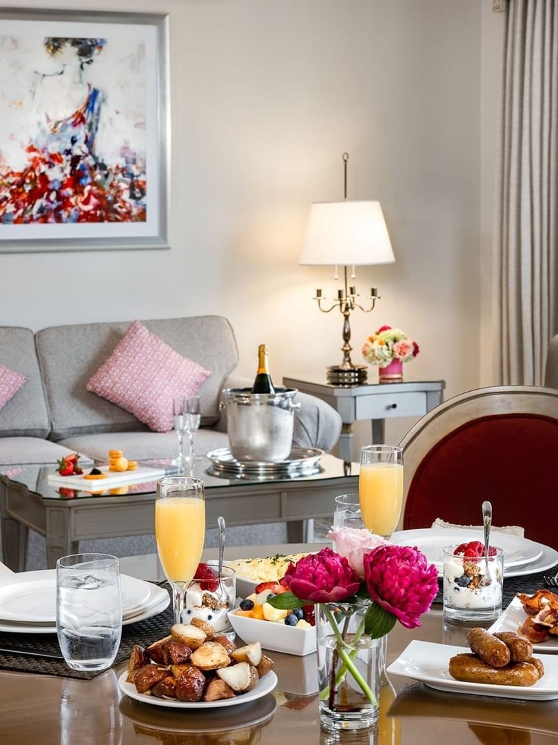 Gourmet breakfast by a grey sofa under colorful art in a luxury dining area at Warwick Hotels & Resorts