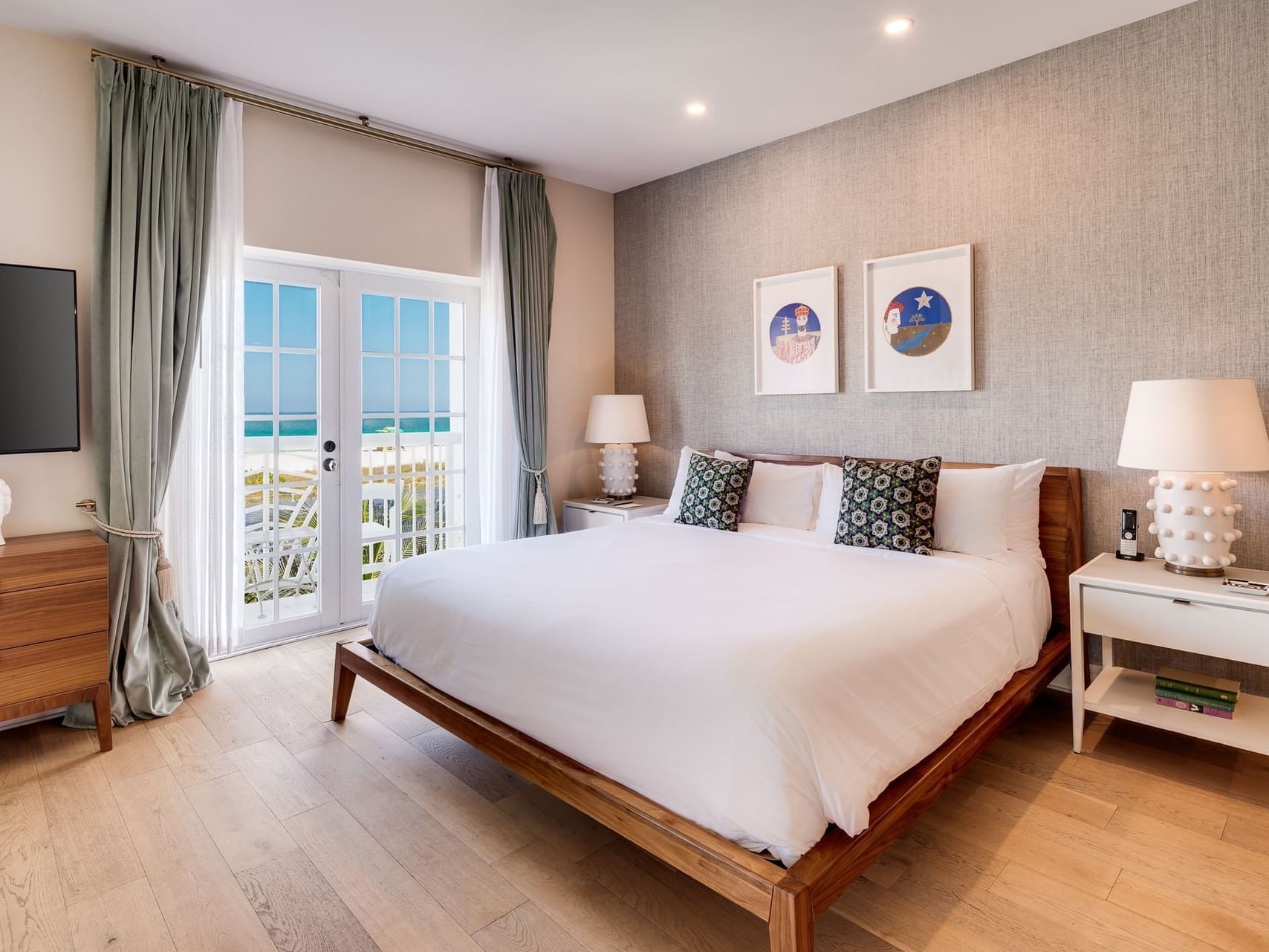 Two Bedroom Oceanfront Suite with Balcony featuring cozy bed & TV at The Savoy Hotel & Beach Club
