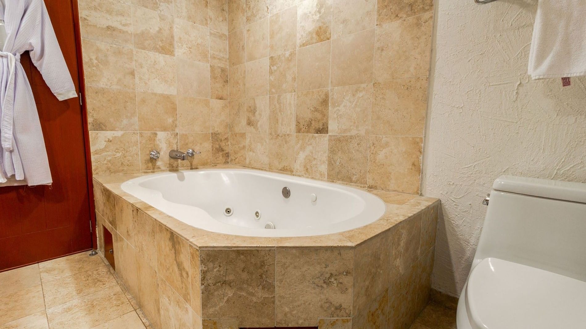2 Double Camino Real Club Executive bathroom featuring a large jetted soaking tub and a bathrobe at Camino Real Guadalajara