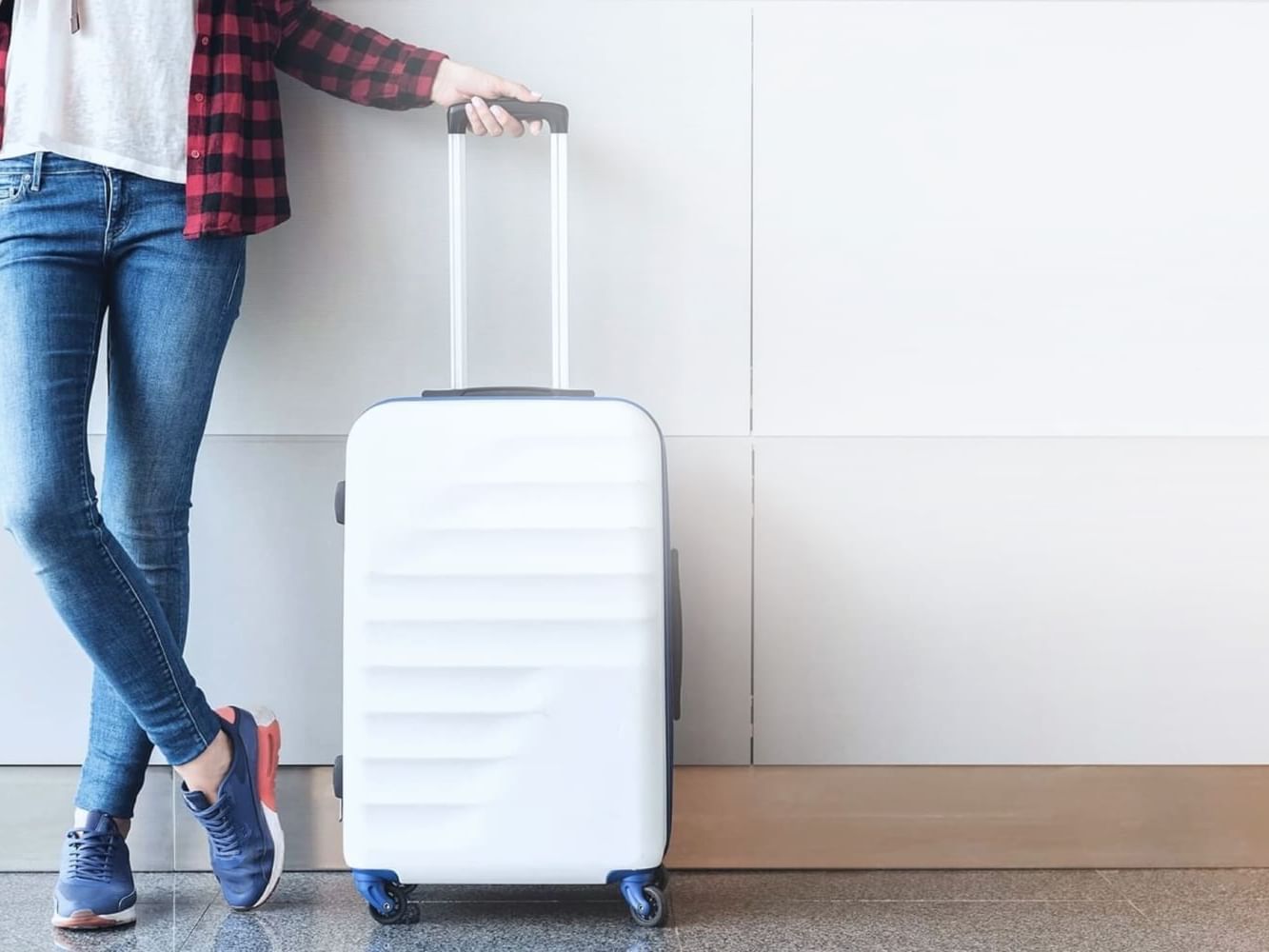 A lady standing next to her luggage at VE Hotel & Residence