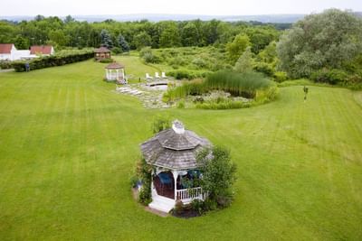 High angle view of white gazebos on lawn next to pond with water lilies at La Tourelle Hotel and Spa